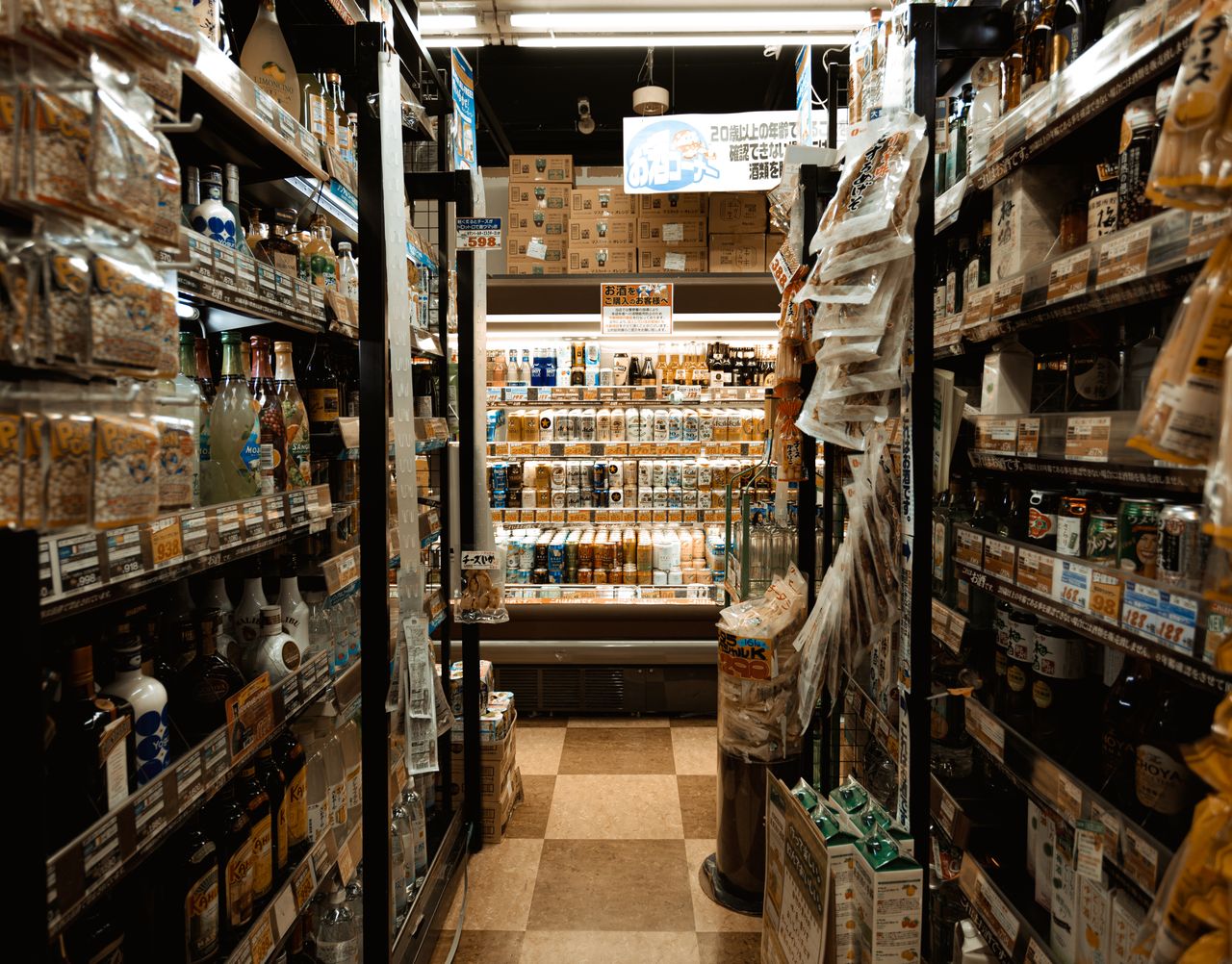 the-story Explore a bustling Tokyo convenience store aisle packed with diverse products and merchandise.